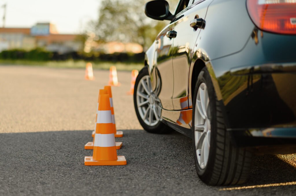 Refresher Lessons - An image with a car making manoeuvres between road bollards in a Driving Test area.